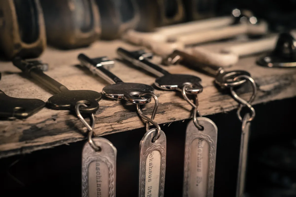 Old room keys with metal tags hanging from a wooden rail
