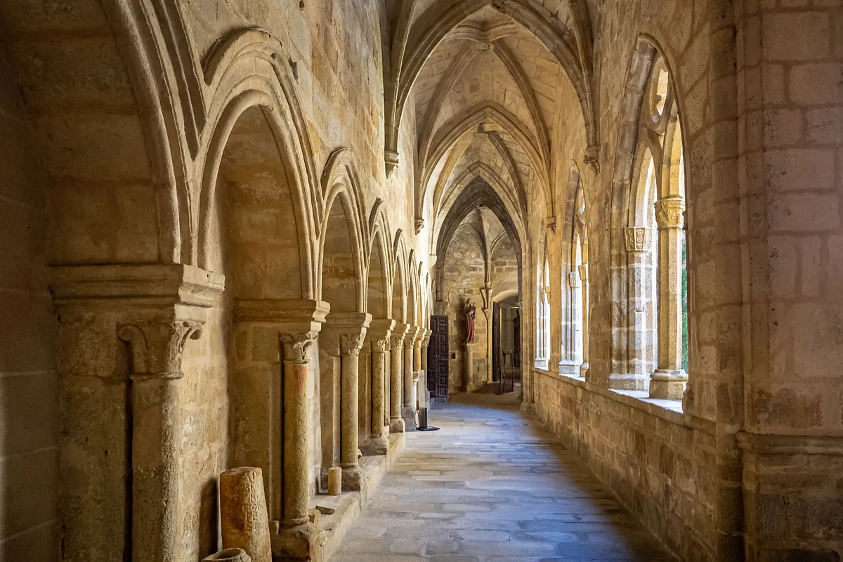 A stone cloister corridor with Gothic arches in a Spanish monastery